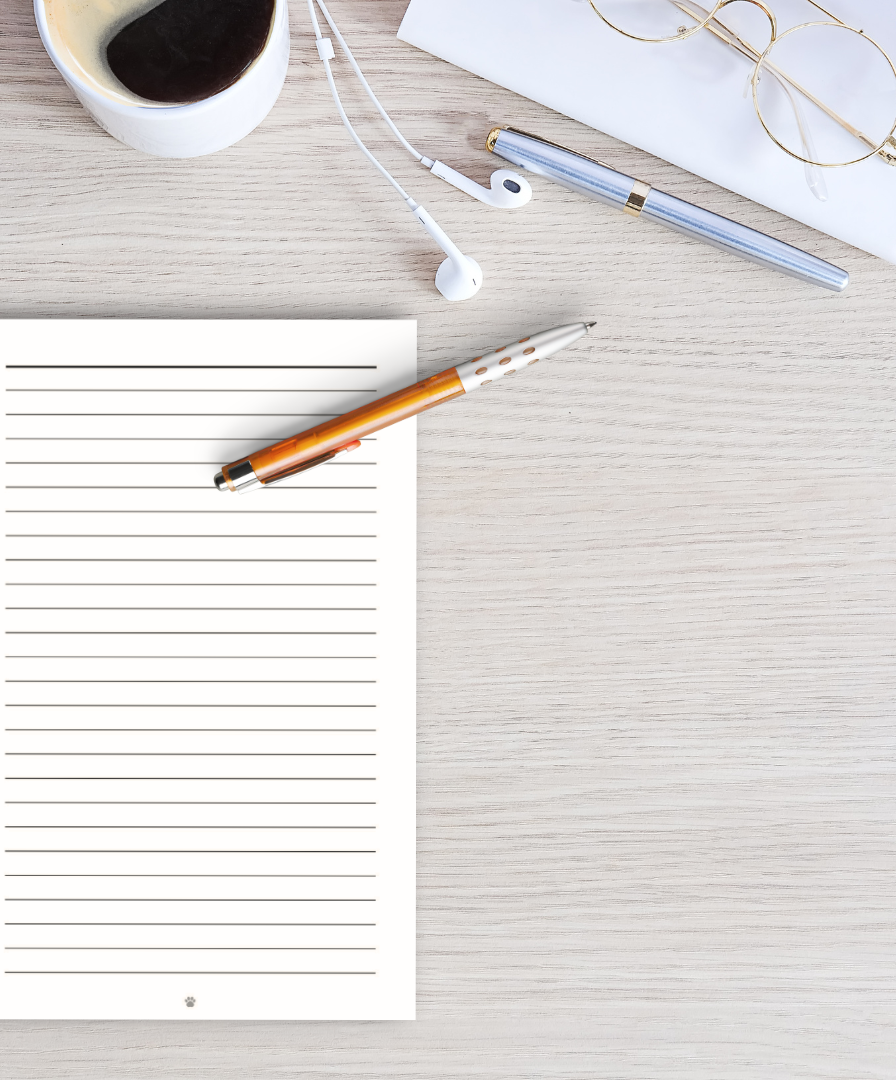 Notebook with a pen, coffee cup, and glasses on a wooden surface