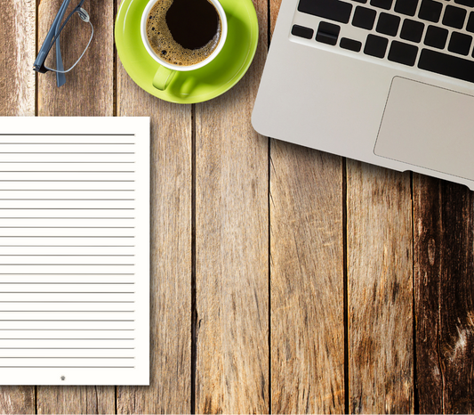 Notebook, coffee cup, and laptop on a wooden desk